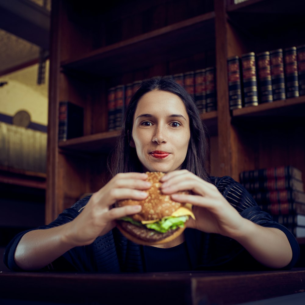 mujer sosteniendo hamburguesa