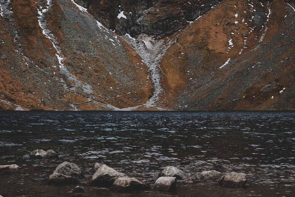 landscape photography of body of water and mountain slope