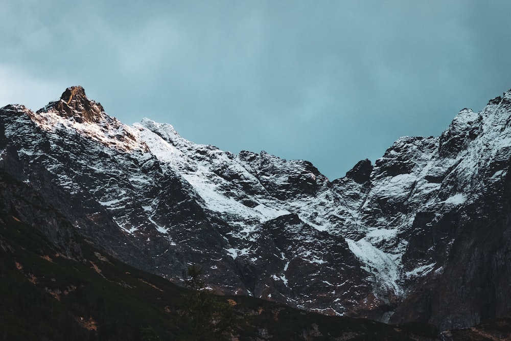 snow covered mountain under cloudy sky