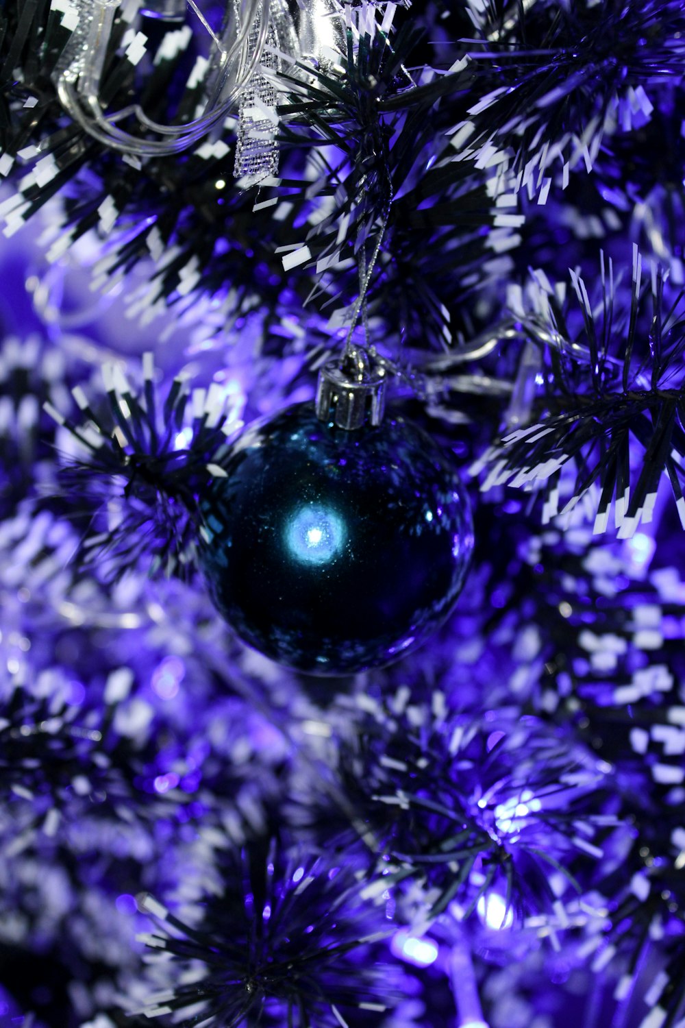 blue bauble in front of purple tinsel