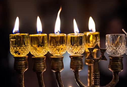A radiant 7-branch menorah glowing softly against a dark background, symbolizing faith and light.
