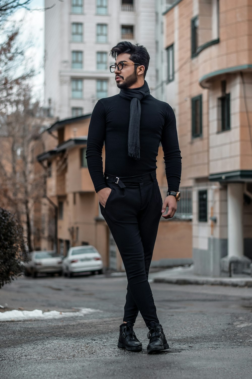 homem na camisa social preta, gravata e calças em pé na rua