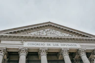 The image features the facade of an imposing classical building with large columns and a detailed pediment. The words 'CONGRESO DE LOS DIPUTADOS' are inscribed prominently on the structure, indicating its governmental function.