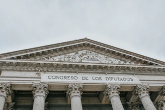The image features the facade of an imposing classical building with large columns and a detailed pediment. The words 'CONGRESO DE LOS DIPUTADOS' are inscribed prominently on the structure, indicating its governmental function.