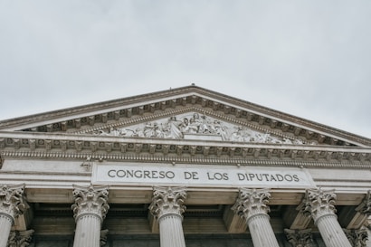 The image features the facade of an imposing classical building with large columns and a detailed pediment. The words 'CONGRESO DE LOS DIPUTADOS' are inscribed prominently on the structure, indicating its governmental function.