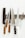 A series of kitchen knives with wooden handles are arranged on a magnetic strip against a white background. Each knife varies in size and style, and they are displayed in an orderly fashion.