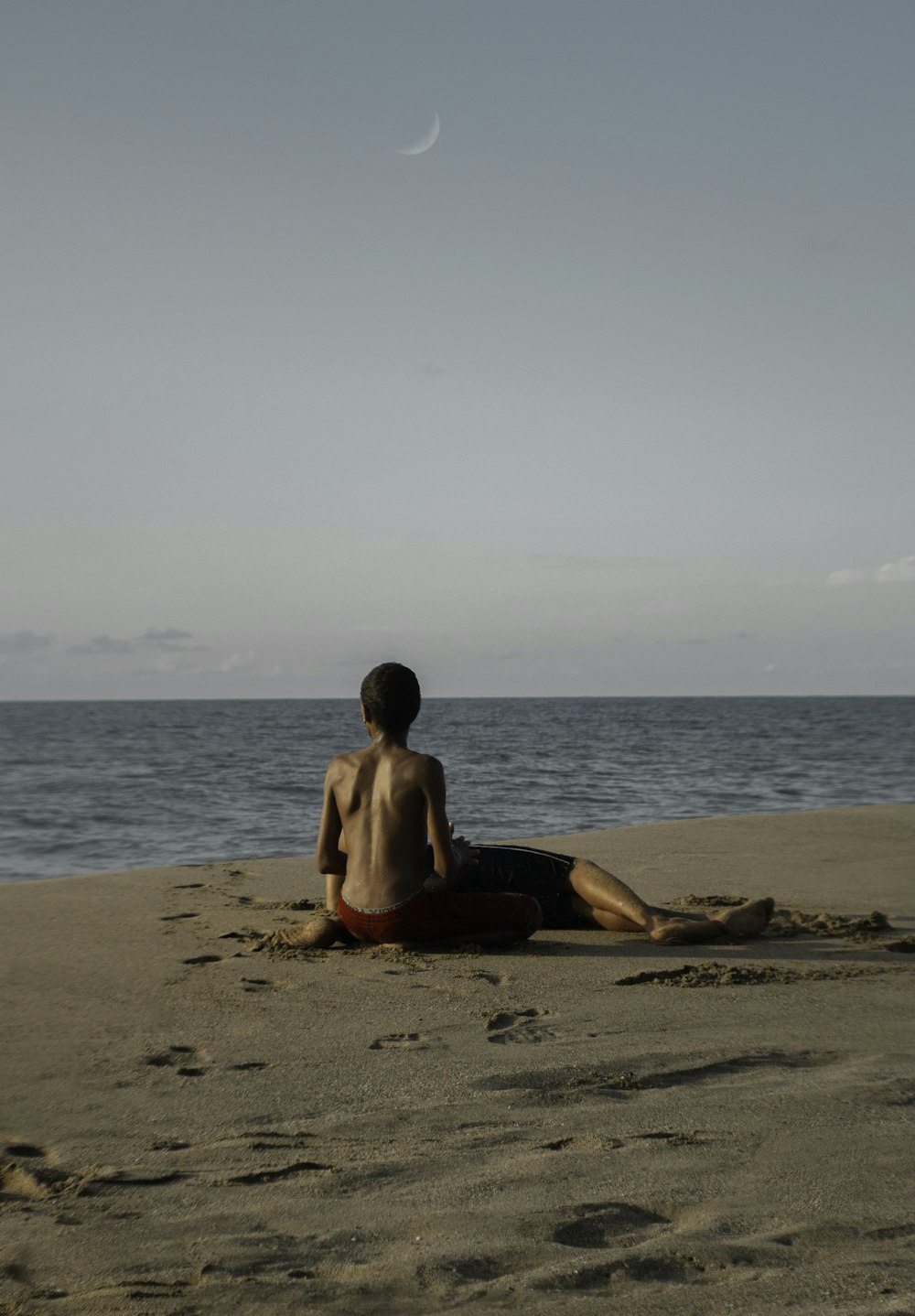 boy sitting on shore