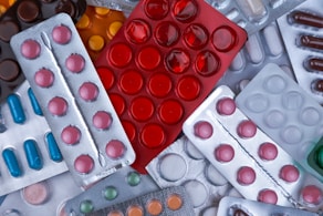 pile of blister packs of colorful medicine tablets