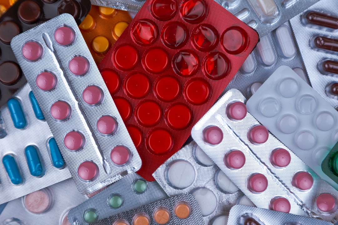 Heap of medical pills in white, blue and other colors. Pills in plastic package. Concept of healthcare and medicine.