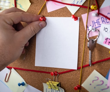 shallow focus photo of white paper sheet mounted on cork board