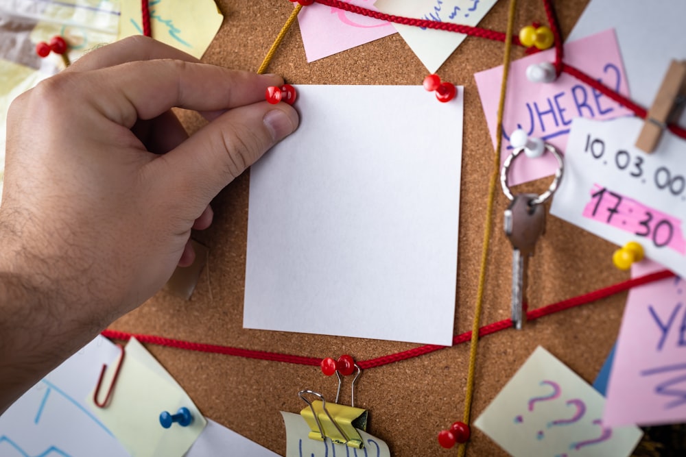 shallow focus photo of white paper sheet mounted on cork board