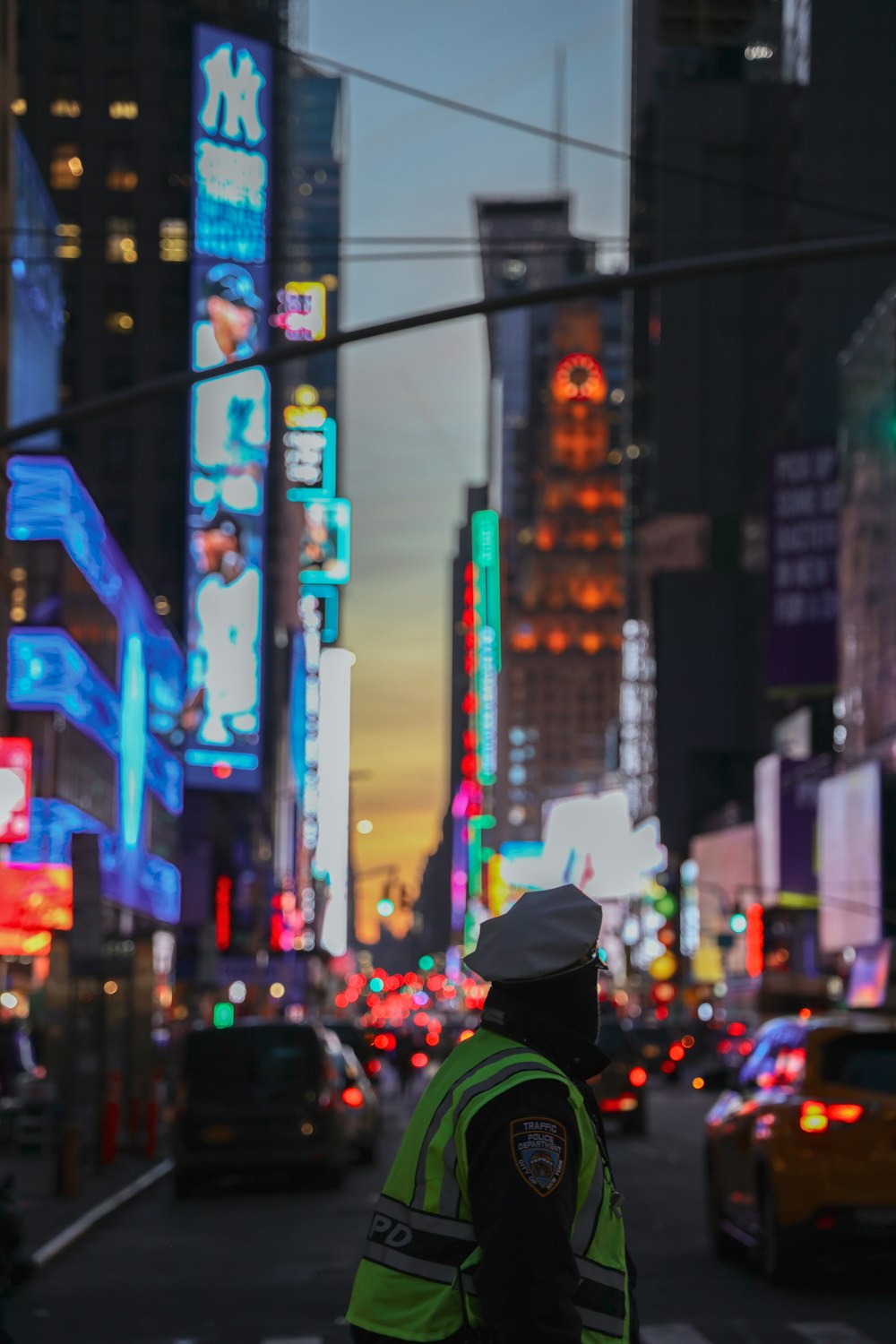 selective focus photo of man walking on the street with row of vehicles