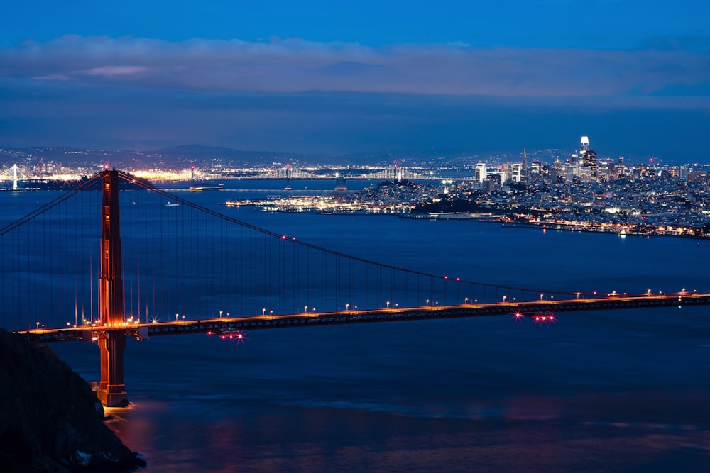 bridge, sea, and city during night