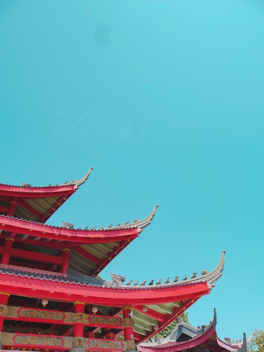 low-angle photography of red and green pagoda building under a calm blue sky in Sam Poo Kong Temple Indonesia