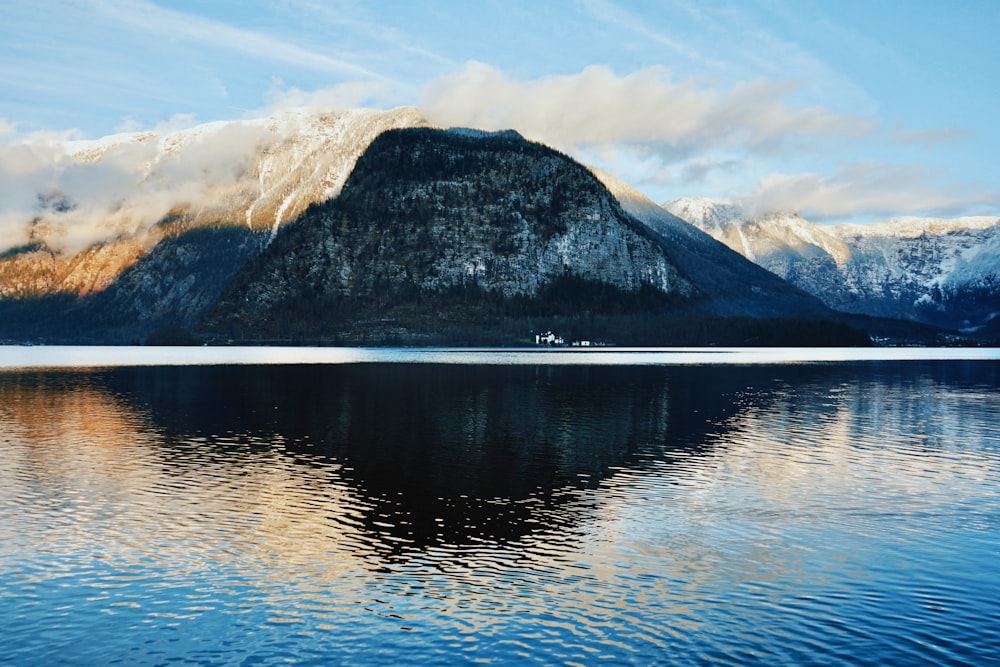 body of water with the distance of mountain during daytime