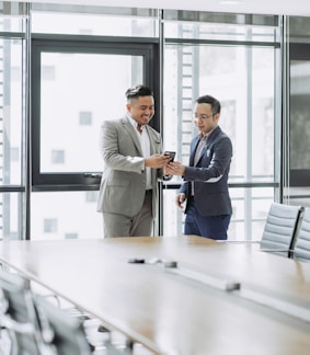 two men shaking hands in a conference room