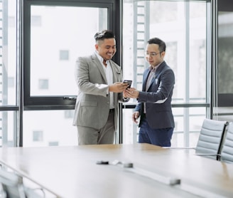 two men shaking hands in a conference room