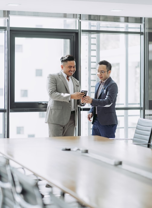 two men shaking hands in a conference room