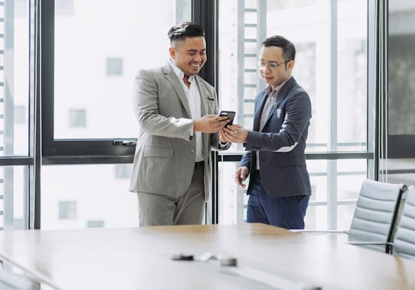 two men shaking hands in a conference room