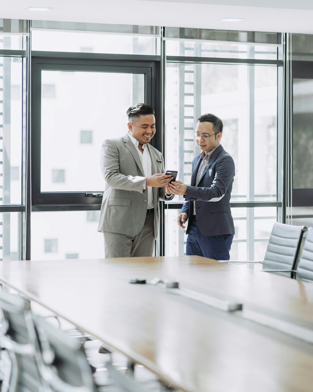 two men shaking hands in a conference room