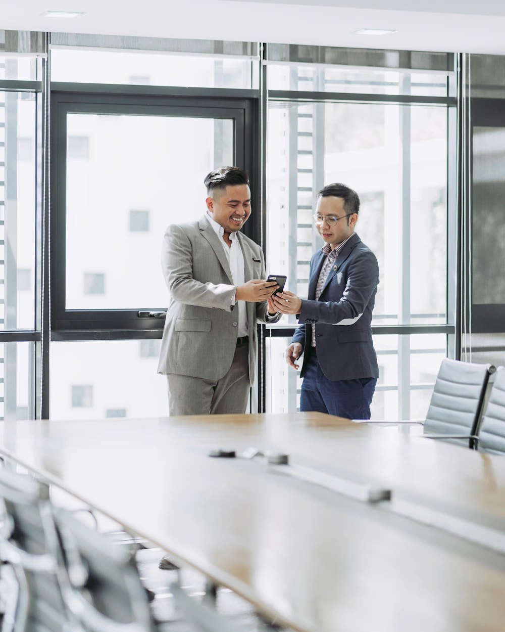 Two business professionals discussing trade documents in a meeting room