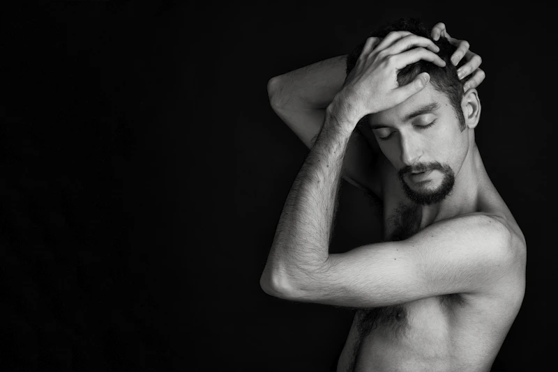 Grayscale portrait of a shirtless Indian man