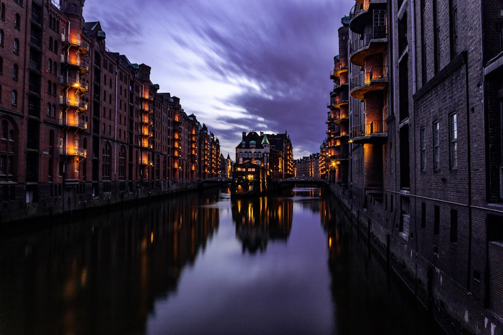 city with high-rise buildings near body of water under gray and black sky