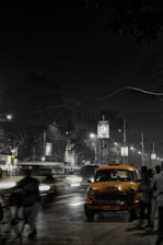 A modern taxi car parked on a city street at sunset.