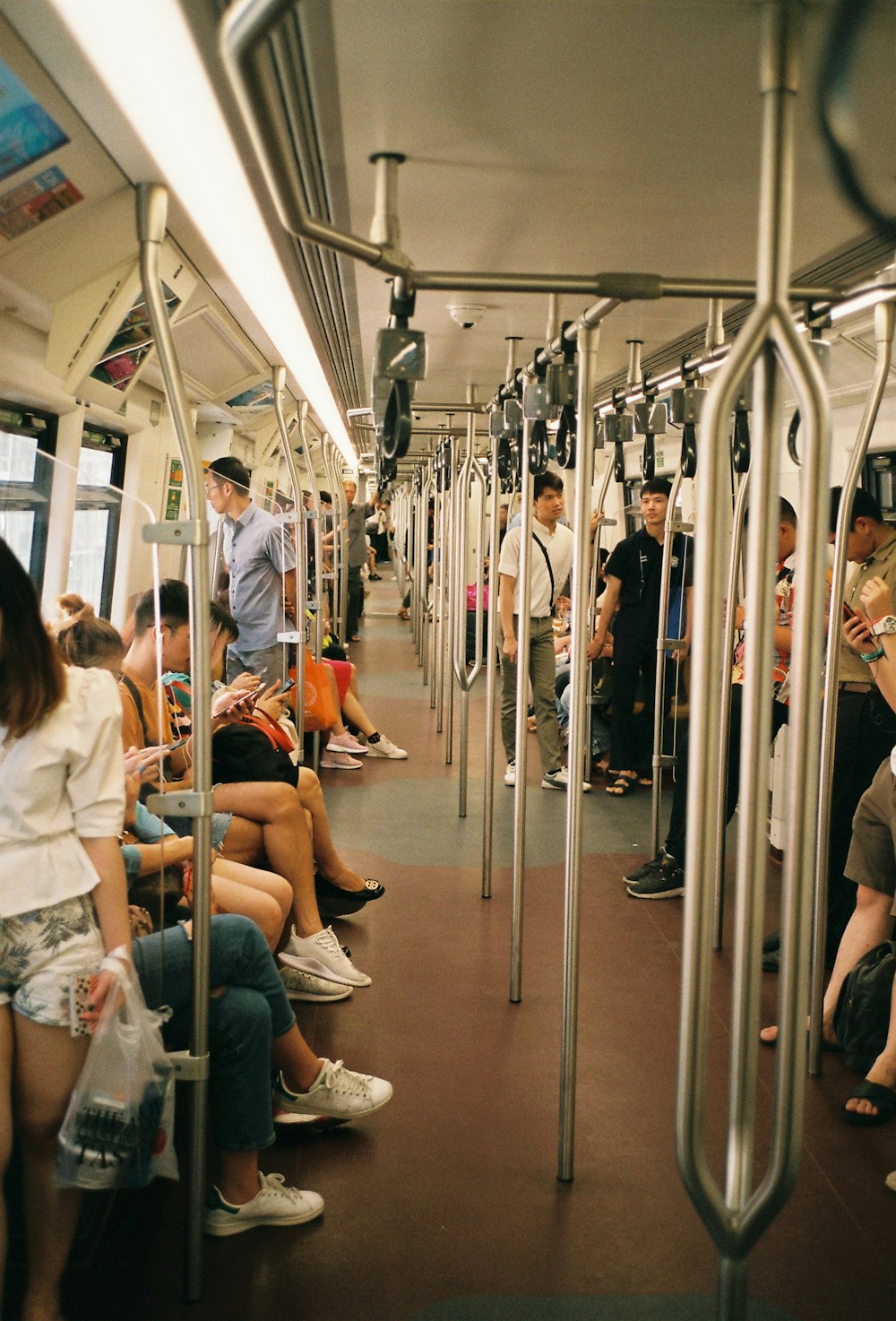 people sitting and others are standing inside train