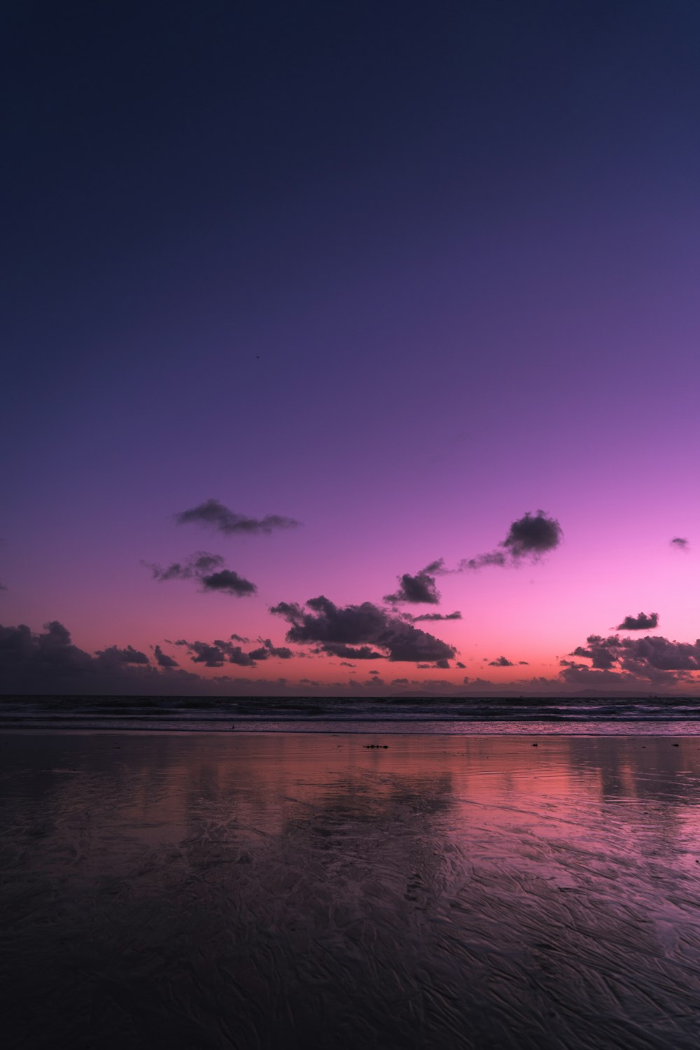 ocean under cloudy sky during nighttime