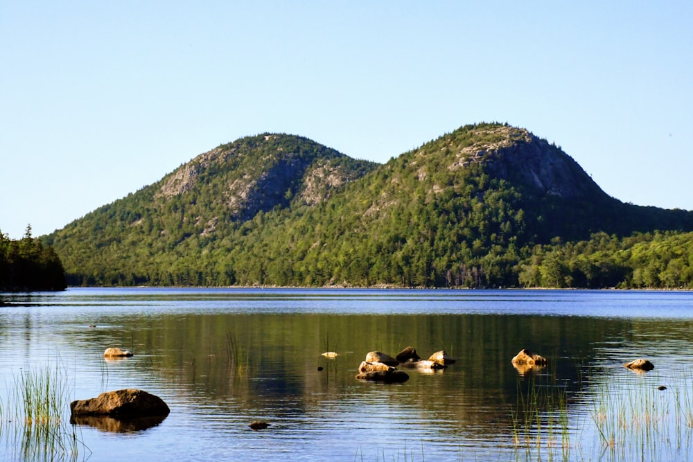 rock formations on body of water viewing mountain during daytime