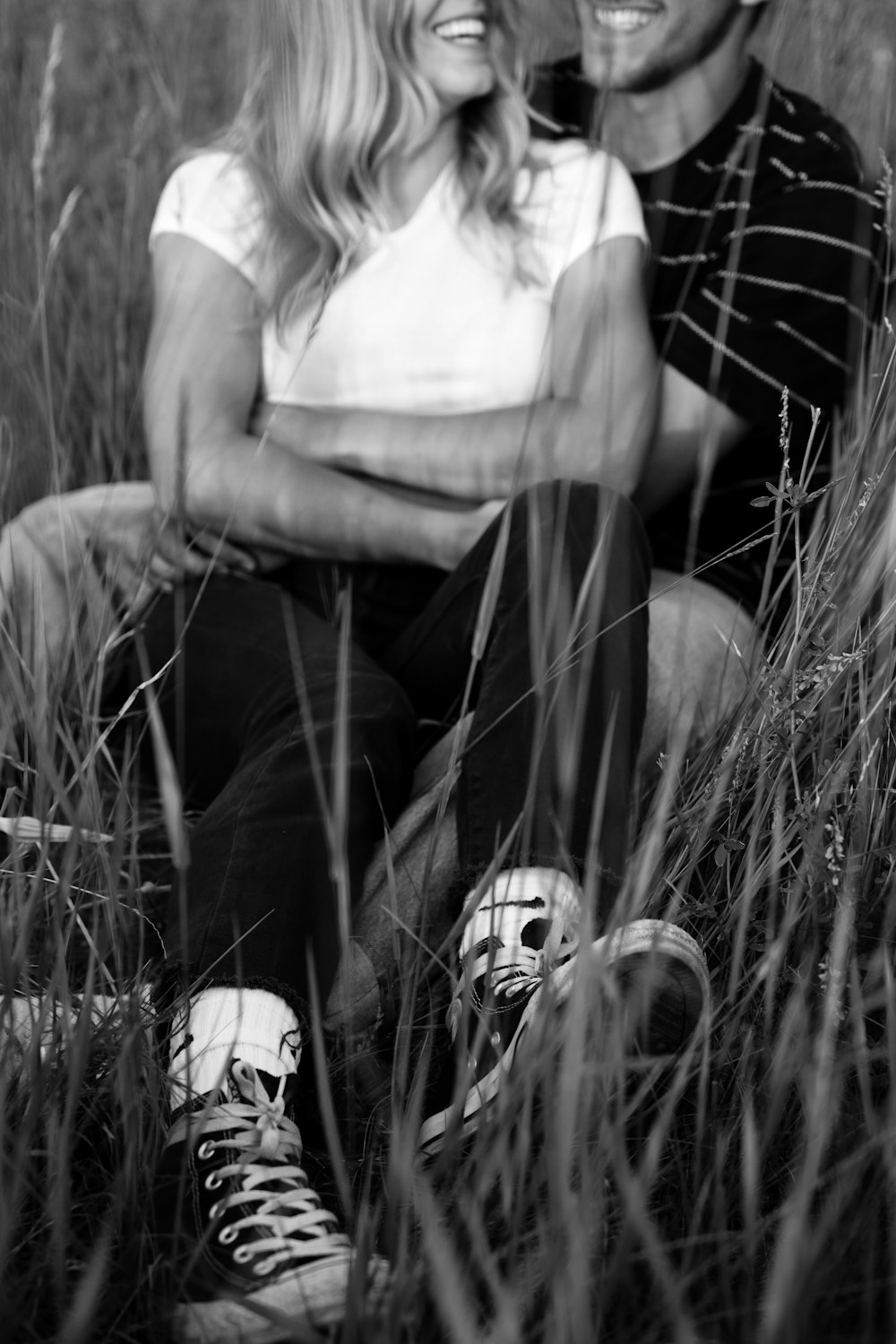 grayscale photography of couple sitting on grass