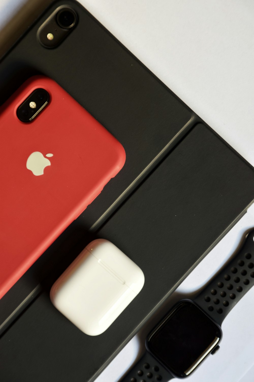 shallow focus photo of space gray iPhone with red case