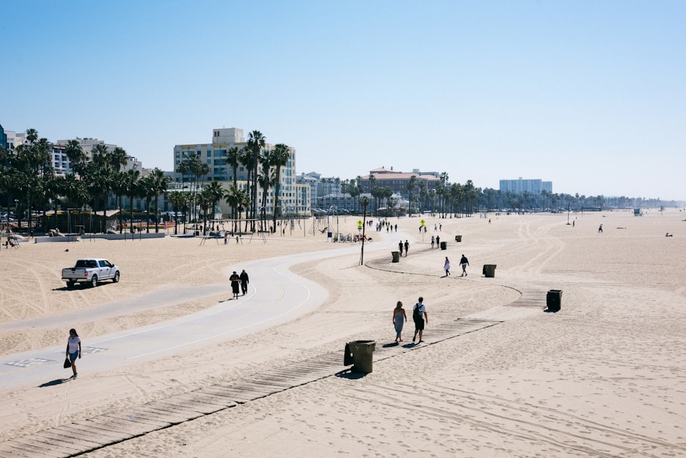 a group of people walking across a sandy beach