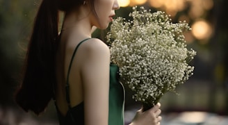 woman in green dress holding flowers