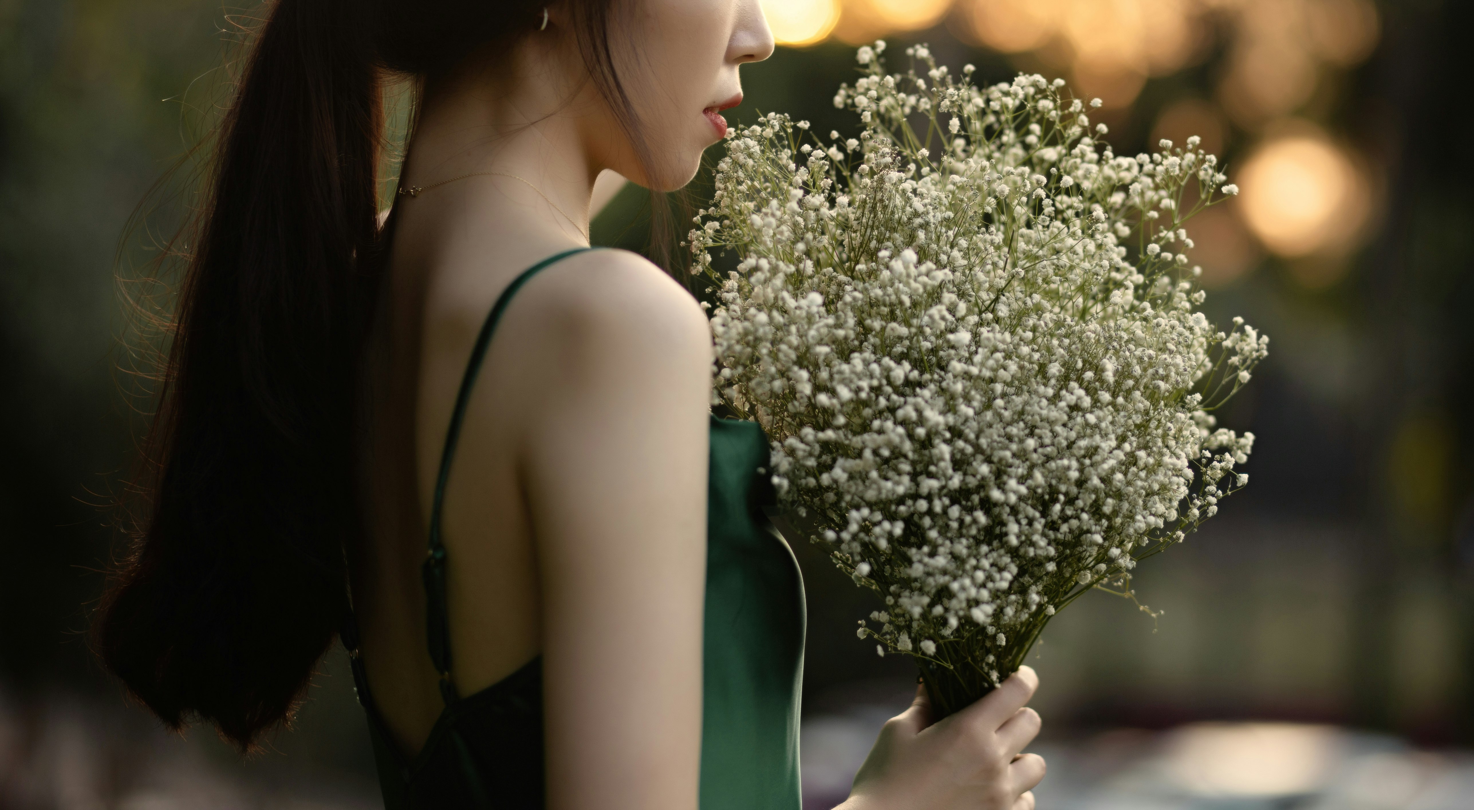 woman in green dress holding flowers