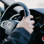 shallow focus photo of person driving Honda car