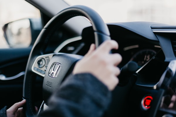 A driver’s hands on a car steering wheel