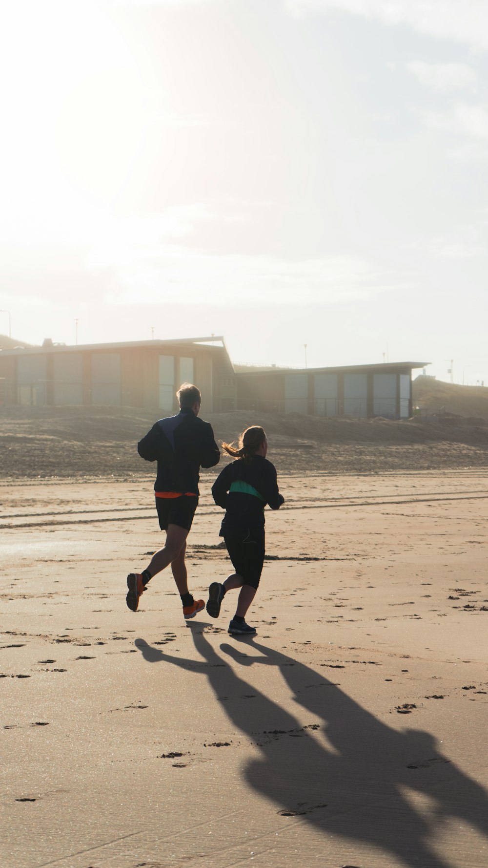 a man and a woman running on a beach