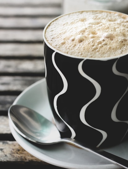 A close-up of a coffee jelly cup with rich dark coffee tones and a wooden spoon beside it.