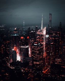 A nighttime aerial shot of iconic global cities illuminated with vibrant red lighting, symbolizing strength and leadership.