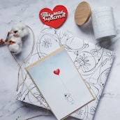 A romantic flat lay of blush pink and red themed Valentine’s Day gifts with delicate heart decorations.