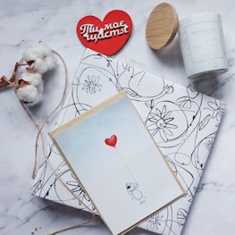 A romantic flat lay of blush pink and red themed Valentine’s Day gifts with delicate heart decorations.