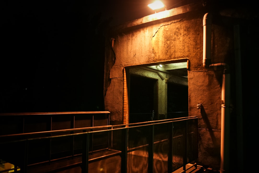 brown concrete building showing lighted outdoor lamp