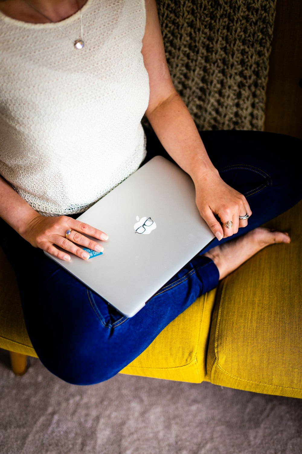 sitting person holding closed laptop