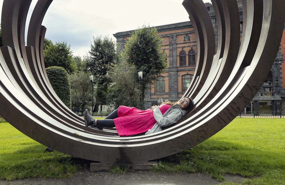 woman smiling and lying on tunnel structure near building