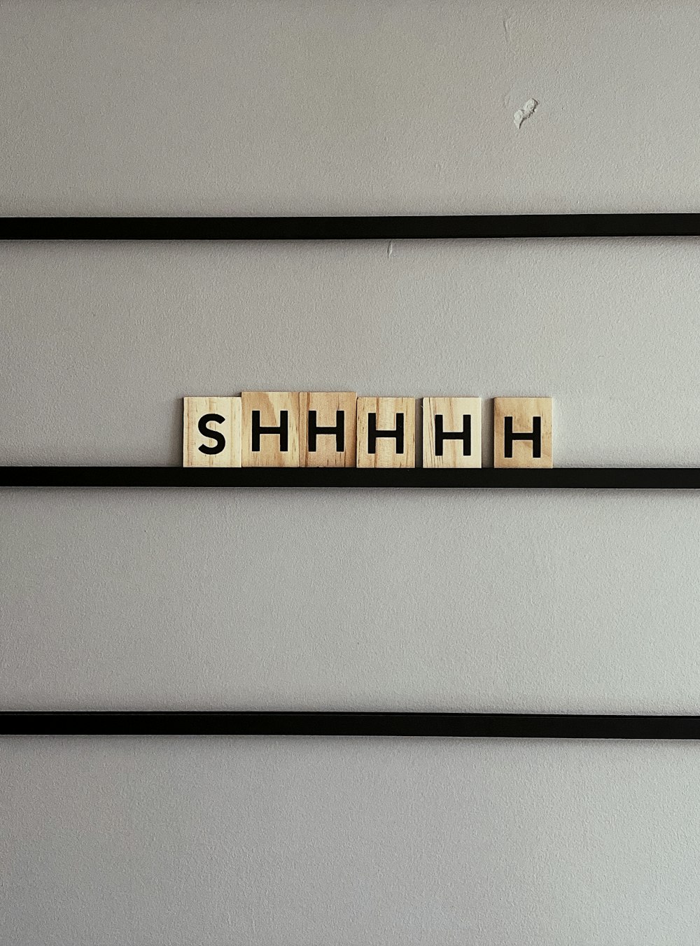 Shhhhh scrabble pieces on gray surface