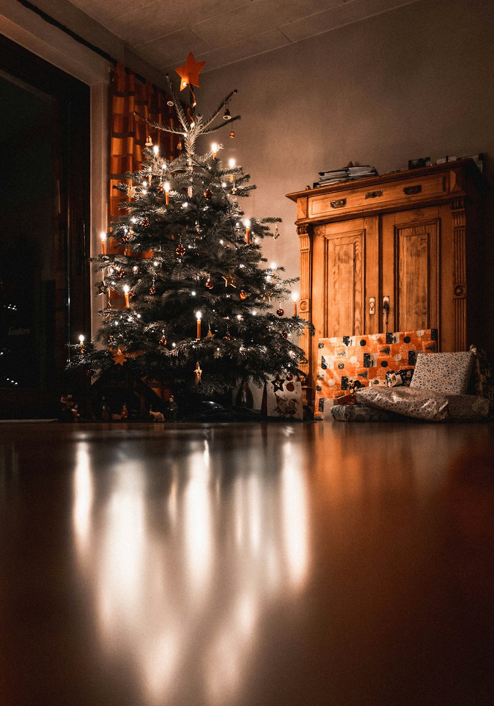 Árbol de navidad con mini luces de cadena encendidas cerca del gabinete