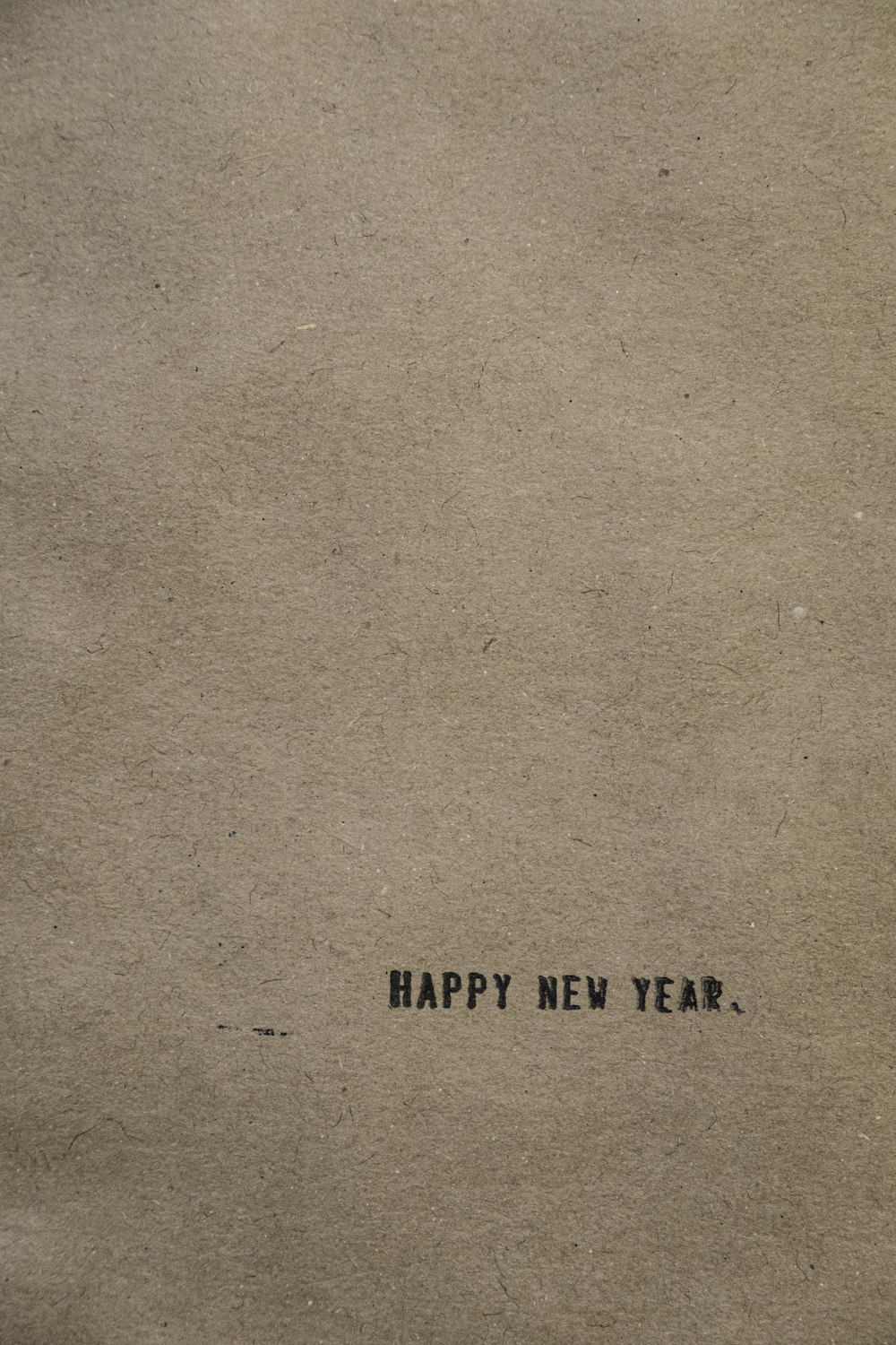 a piece of brown paper with the words happy new year written on it