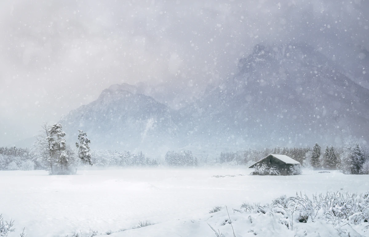House covered with heavy snow near mountain